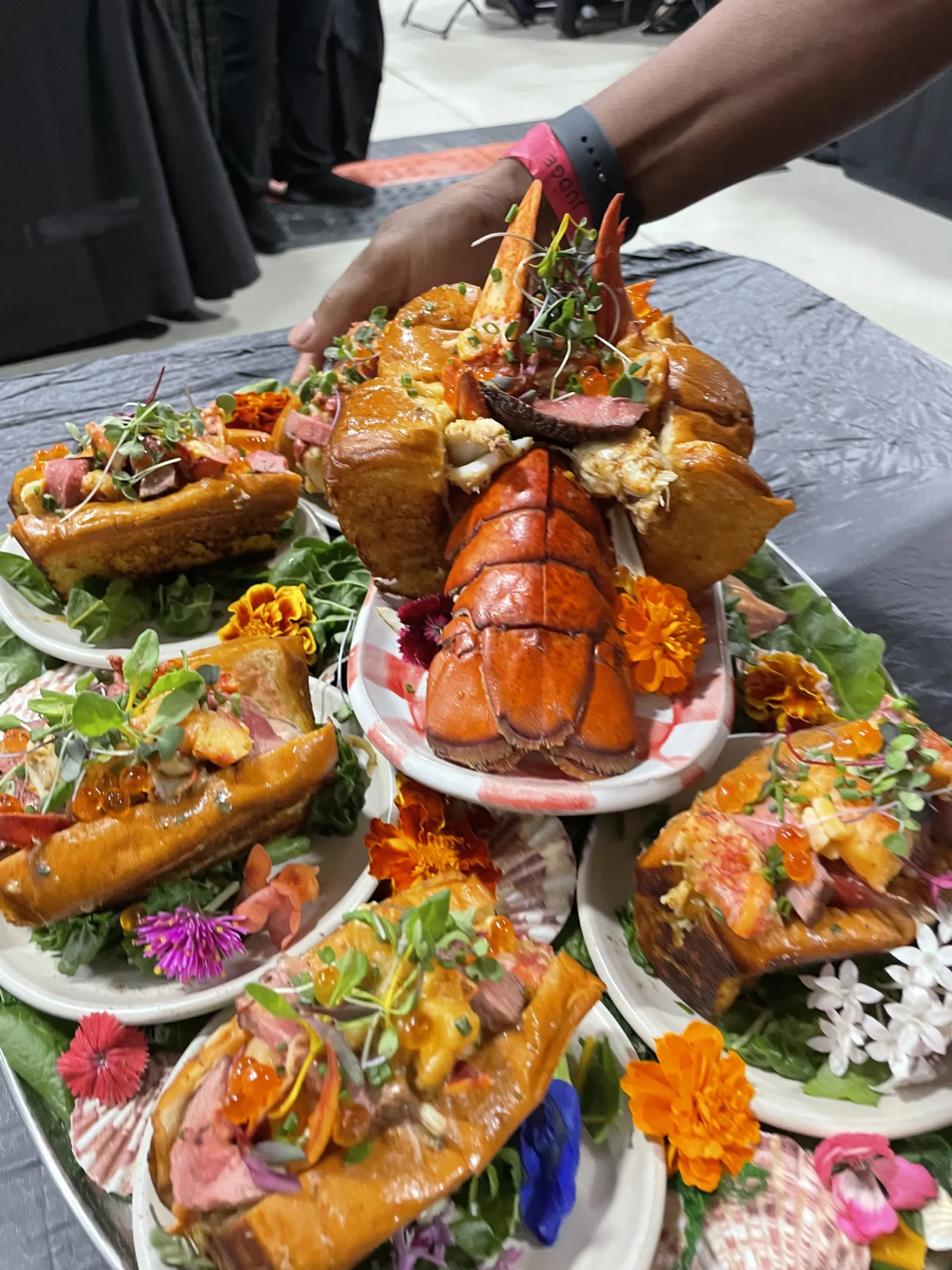 A high-scoring, meticulously plated lobster dish from the World Food Championships, garnished with microgreens and edible flowers.
