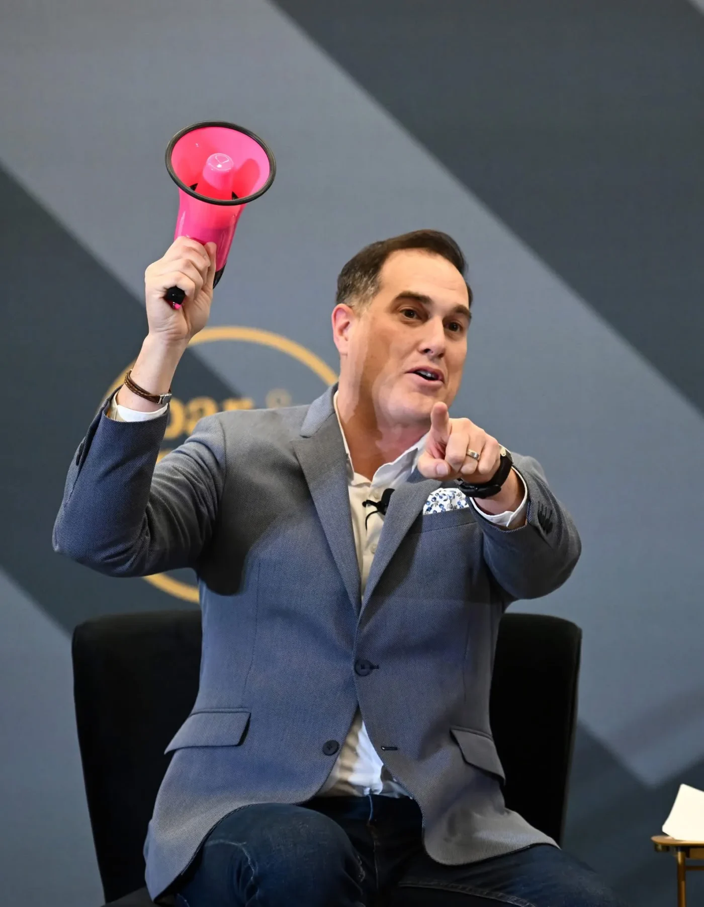 Art Sutley holding a pink megaphone on stage while addressing the audience at the Bar & Restaurant Expo