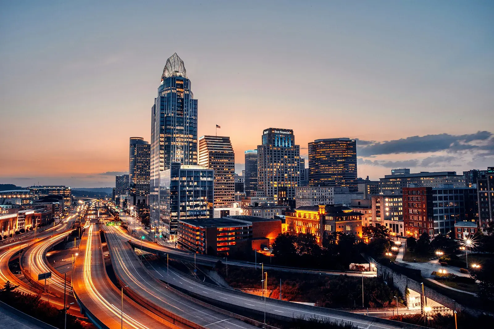 Cincinnati skyline at dusk with light trails on the highways into downtown