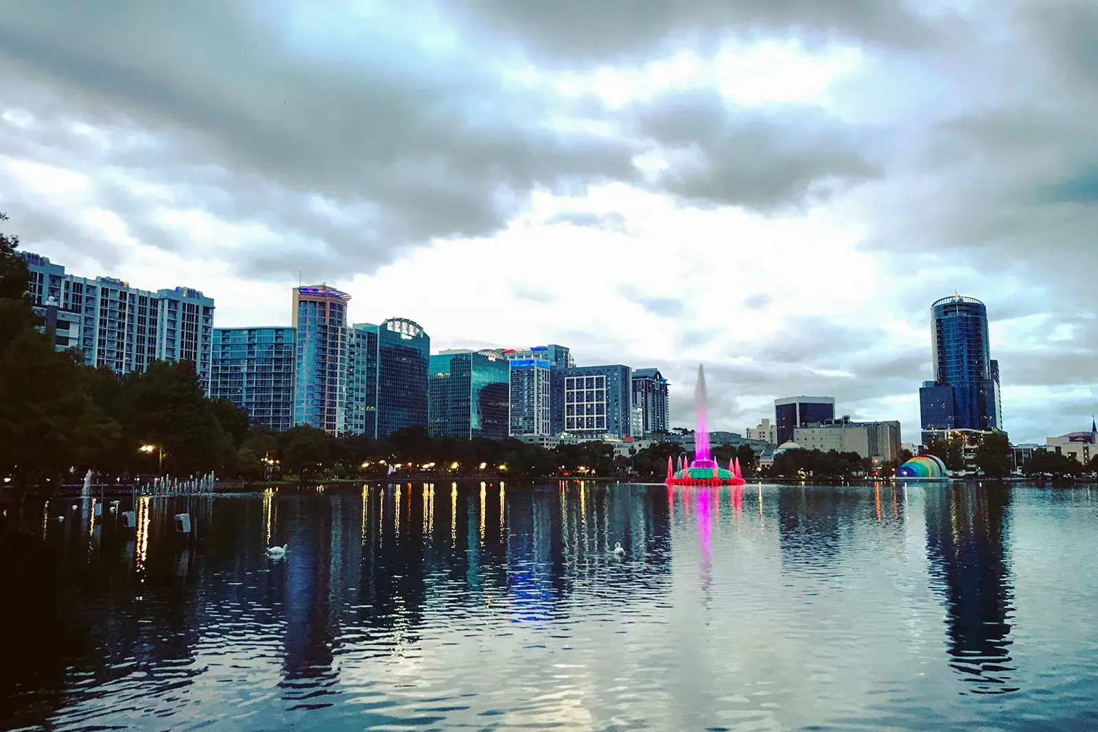 Downtown Orlando skyline and the lit fountain on Lake Eola at dusk